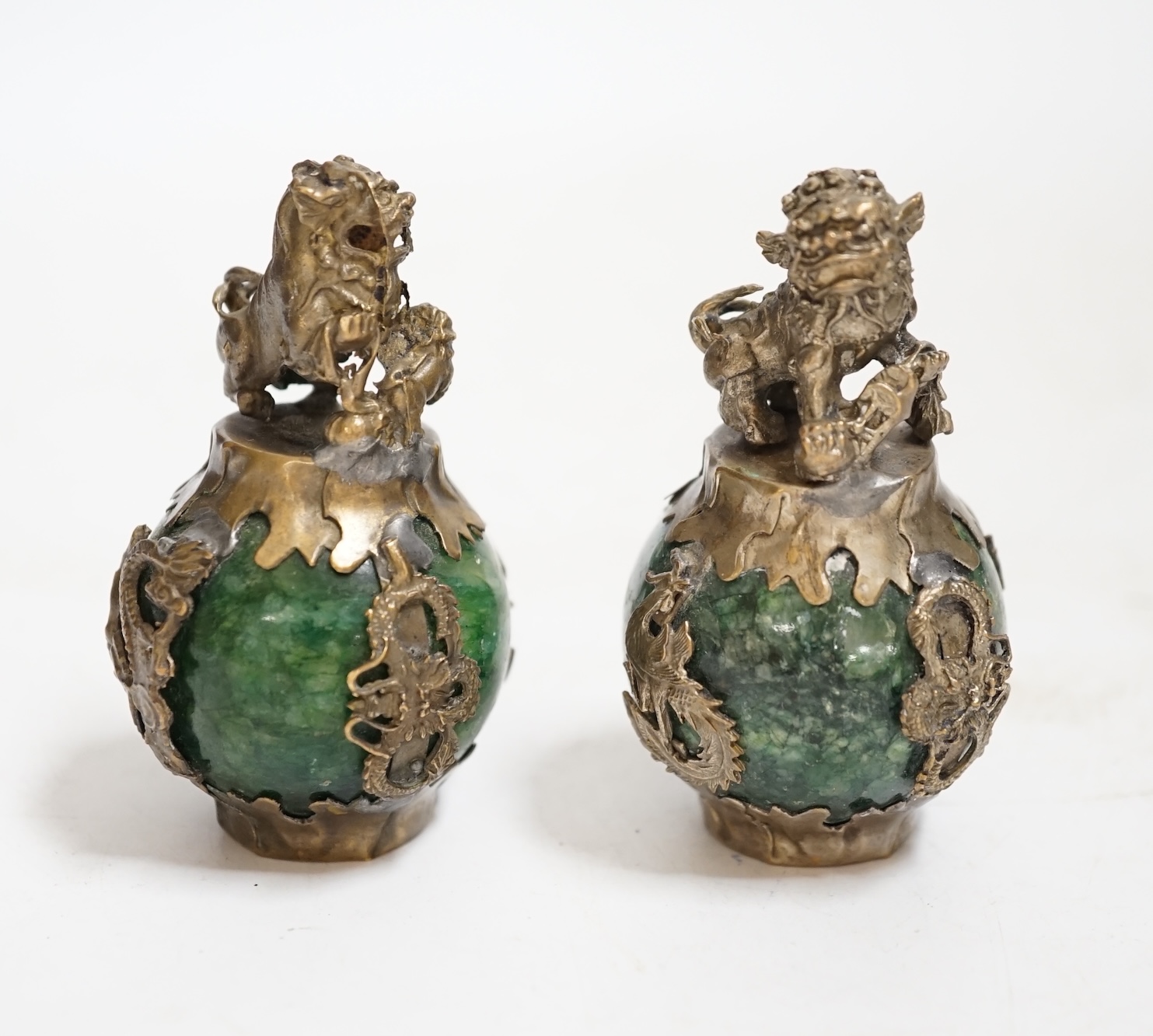 A pair of Chinese Buddhist lion hardstone and brass mounted paperweights, 7cm high., Condition - fair